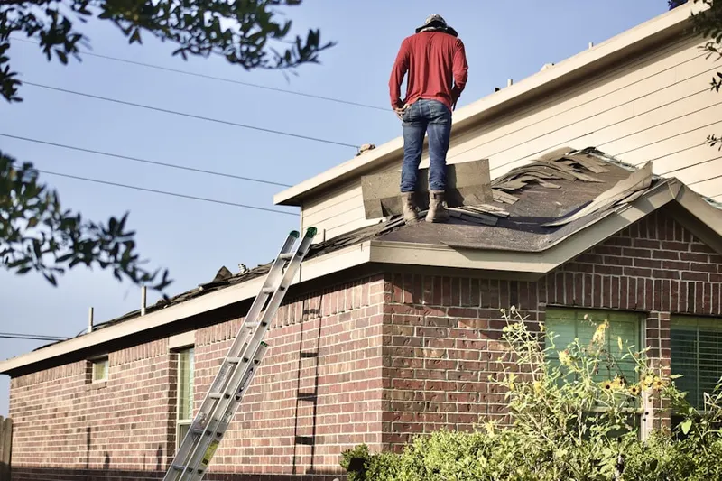 Professional roofer working on a residential roof in Woodland Forest